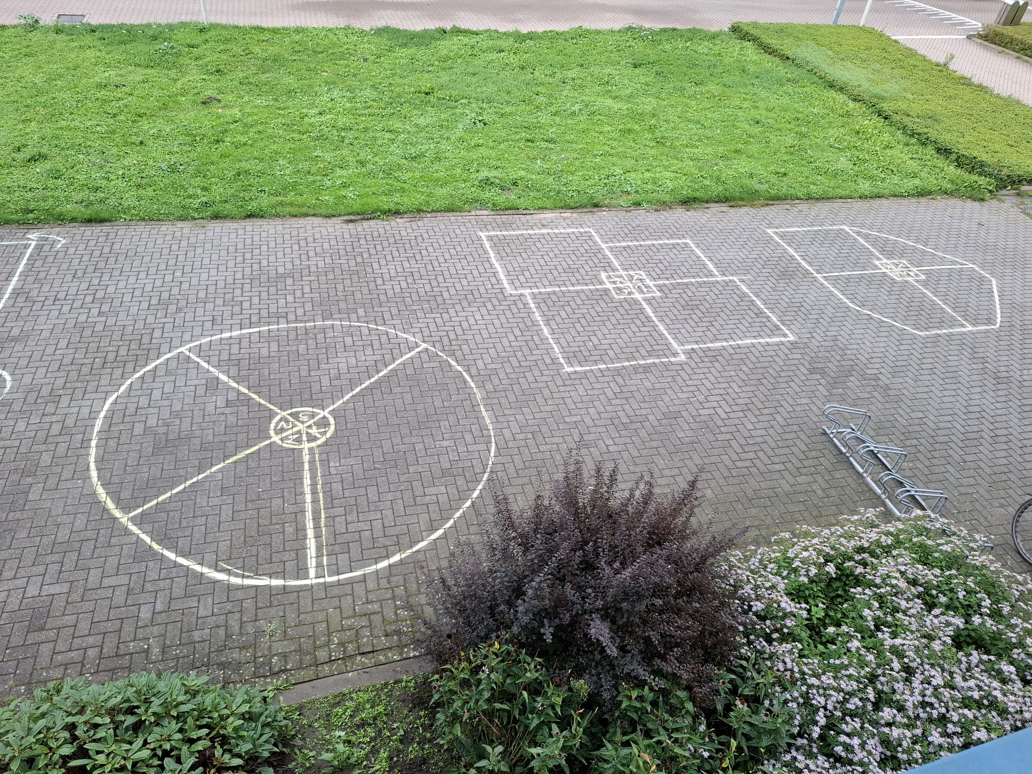 Buitenruimte met verschillende met stoepkrijt getekende spelvakken